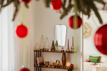 Shelf decorated with candles, small Christmas trees, and festive ornaments. Warm lights create a charming holiday atmosphere.