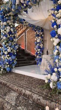 Luxury drone shot of a white and blue floral wedding arch on an Italian villa terrace, hydrangeas and elegant decor framing an unforgettable destination ceremony under soft light