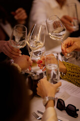 Hand with a glass of wine in the night atmosphere of the restaurant