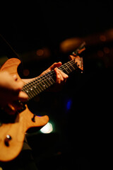 Naklejka premium Close up look of a man playing the electric guitar during a concert, no faces are shown, shallow depth of field
