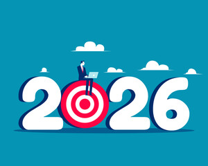 2026. Businessman using laptop sitting on archery target 2026
