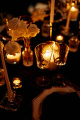 Luxurious setting of dark restaurant tables with candles and fresh flowers