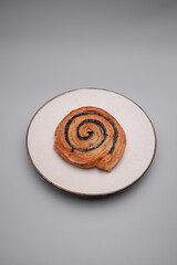 Austrian poppy seed roll presented on a plate on grey background