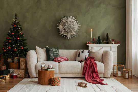 Cozy living room with a Christmas tree, beige sofa, and green wall. Warm festive decor with gifts and soft natural light.