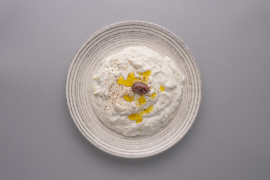 Tzatziki spread with olive and oil on top