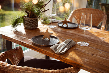 Atmospheric christmas table decoration in a cozy and sunny conservatory with festive bokeh. Gastronomy background.