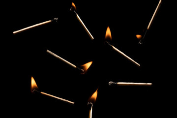 Lit falling match on a black background.