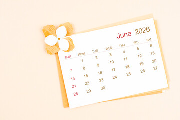 June 2026 calendar with origami flower paper on beige color background.
