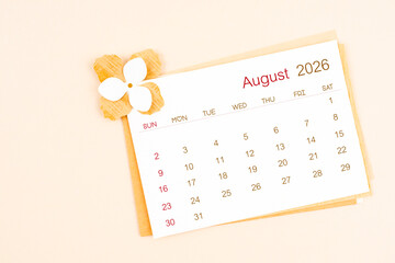 August 2026 calendar with origami flower paper on beige color background.