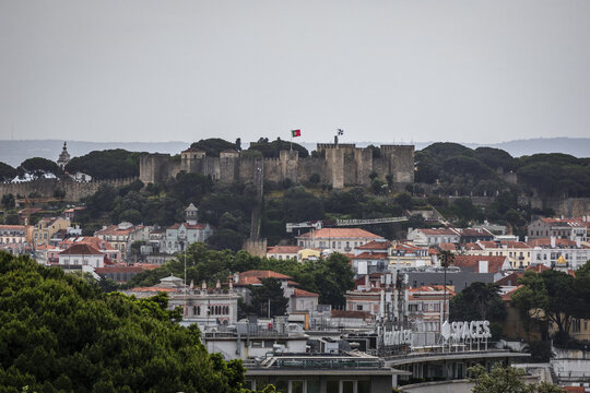View of the ancient S&atilde;o Jorge Castle, perched atop a verdant hill overlooking the red-tiled rooftops of the city below, Lisbon, Lisbon, Portugal.