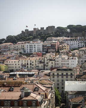 View of sun-kissed terracotta rooftops cascade down the hill towards the ancient S&atilde;o Jorge Castle, a fortress perched high above, Lisbon, Lisbon, Portugal.