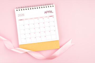 April 2026 desk calendar with pink pastel ribbon.