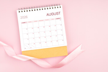 August 2026 desk calendar with pink pastel ribbon.