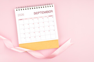 September 2026 desk calendar with pink pastel ribbon.