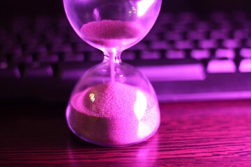 hourglass with the sand and computer keyboard time and work