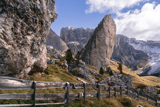 View of rugged, towering peaks rise majestically against a clear blue sky, their snow-dusted summits contrasting with the earthy tones of the foreground, Ortisei, Trentino-Alto Adige, Italy.