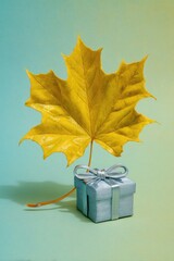 Yellow Maple Leaf And Silver Gift Box On Teal Background