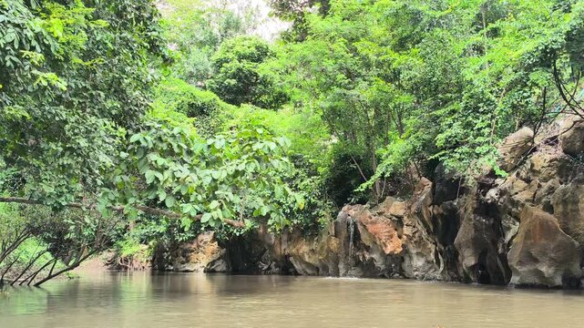 traveling sailing on river lake near cascade waterfall in tropical forest jungle