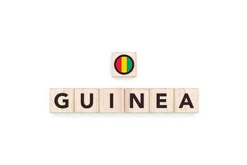 Wooden blocks bearing the name and flag of Guinea. Guinean and African Culture, national identity, travel, and geography in an advertising space design.