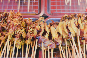 Grilled squid skewers are ready for sale at a market.