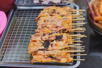 Grilled squid skewers are ready for sale at a market.