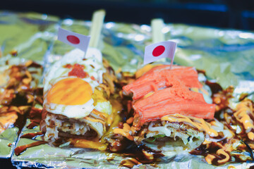 Japanese-style crepes with toppings, sauce, and small flags.