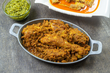 rendang ayam padang, rendang is one of West Sumatra delicious meat based dishes, served on a gray plate.