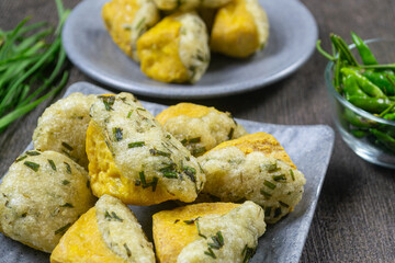 Tahu aci khas tegal served on a grey plate, snack made from tofu that is split, then filled with tapioca flour mixture, chives leaves, and other spices before being fried. indonesia food