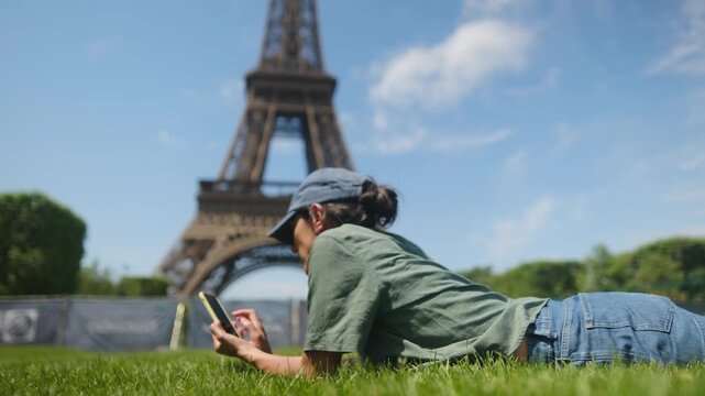 Hands holding smartphone to film and share the eiffel tower from a low-angle perspective in paris, capturing travel memories, architecture and urban summer sightseeing for social media