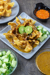 Batagor pangsit served on a grey plate,  Sundanese dish from Indonesia, consisting of fried fish dumplings, served with peanut sauce