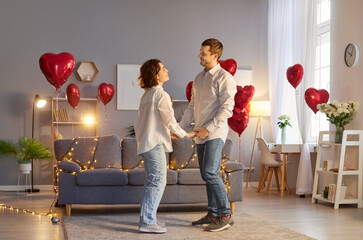 Happy close couple in love at home, man, woman hands holding, red heart symbol, balloons for...