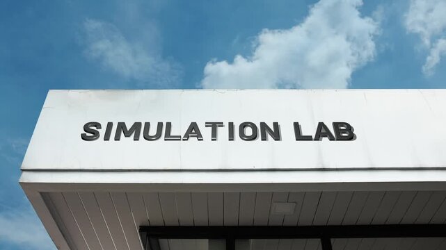 Simulation Lab word sign displayed on a modern training or research building under a clear blue sky, symbolizing immersive learning, virtual reality, technology, practice, and realistic modeling