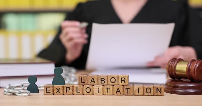 Exploring labor exploitation through documents and legal symbols in a focused workspace