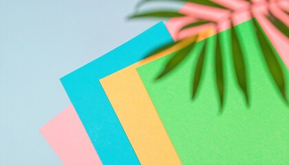 Colorful paper with a tropical palm leaf shadow for a summer theme.