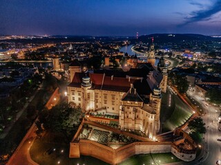 Aerial evening view of Wawel Castle in Krak&oacute;w, Poland, with illuminated walls and Vistula River