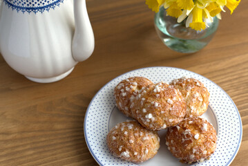 Typical French sweet pastry called chouquettes on plate on wooden table