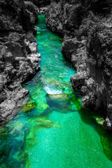 The Soca River in Slovenia is world-famous for its intense turquoise-green color and crystal-clear water. Intensely colored waters with a landscape in dark shades of gray. Natural Wonder in Europe.