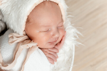 newborn baby sleeping on a bed at home, close-up portrait of a newborn baby sleeping in a cocoon or...