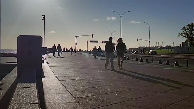Adult couple walking at rambla de montevideo at afternoon springtime day, barrio palermo neighborhood, uruguay