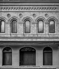 Victorian Brick Building Architecture with Arched Windows and Doorway in Black and White.