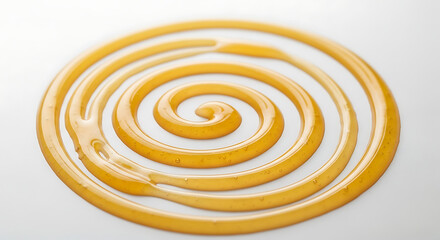 A close up shot of a spiral of caramel sauce on a white surface in a studio setting