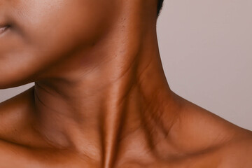 Close-up of elegant female neck and shoulder with smooth dark skin
