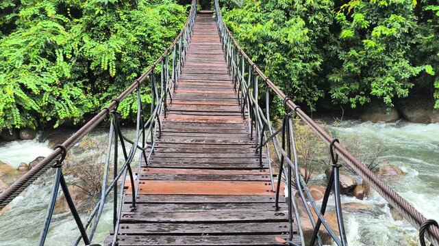 hanging rope suspension bridge footbridge across river in forest