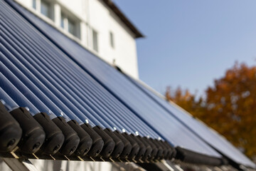 A close-up view of an evacuated tube solar water heater collector. This innovative system, angled towards the sun, represents clean energy, sustainability, and energy-saving technology.