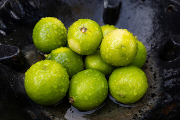 Fresh Green Limes with Water Droplets in a Rustic Setting