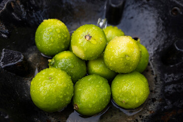 Fresh Green Limes with Water Droplets in a Rustic Setting