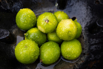 Fresh Green Limes with Water Droplets in a Rustic Setting