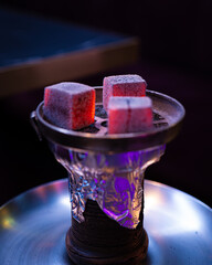 Burning coals on hookah bowl — close-up of a water pipe ready to smoke in a modern lounge