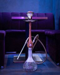 Full hookah on table in lounge bar — modern interior with blue lighting and elegant sofas