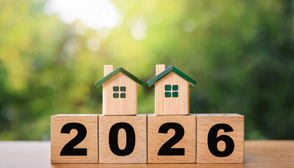 Two Wooden Houses with Green Roofs Sitting on 2026 Blocks Representing Real Estate Growth and Property Investment